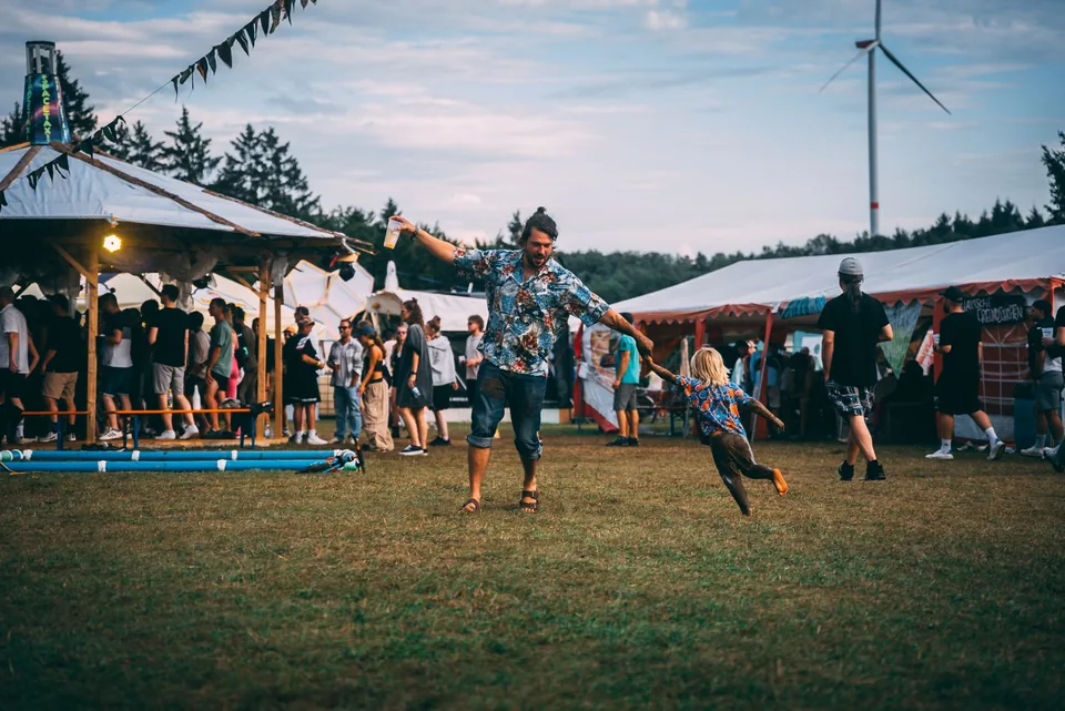 Vater wirbelt sein Kind über die Festivalwiese